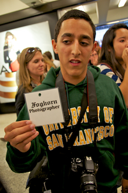 A student photojournalist from the University of San Francisco holding up a credential at a protest he was covering in 2011. 