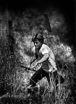 An inmate at an Enfield, Conn., prison running to escape a grassfire that nearly burned him over in 1986. The photo was the first Kodas had published from a wildfire.