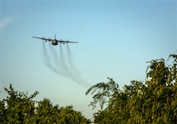 An Air Force Reserve aircrew flying a C-130 Hercules performs aerial spraying of mosquitoes