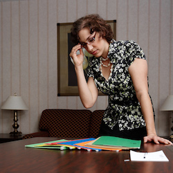Woman looking over folders on conference table