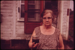 An Ohio woman holds a jar of undrinkable water from her well in 1973, one year before the passage of the Safe Drinking Water Act. EPA funding for the act may now be reduced. PHOTO:  Erik Calonius, DOCUMERICA, Flickr Creative Commons